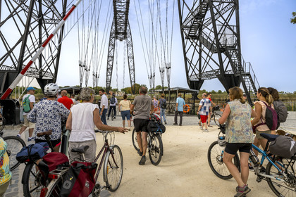 France, Charente Maritime, Rochefort, the Rochefort (or Martrou) transporter bridge built by Ferdinand Arnodin in 1900, cyclist traveling along the cycle route aboard the nacelle in translation above the Charente river
