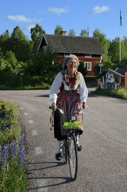 Suède, comté de Dalécarlie, région de Leksand, célébrations du solstice d'été dans le petit hameau de Hjulbäck, femme en costume traditionnel