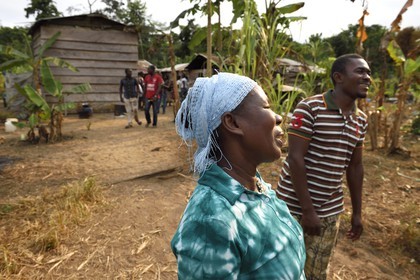 Gabon, province de Ogooué- Maritime, Omboué, région du Loango, femme devant sa maison