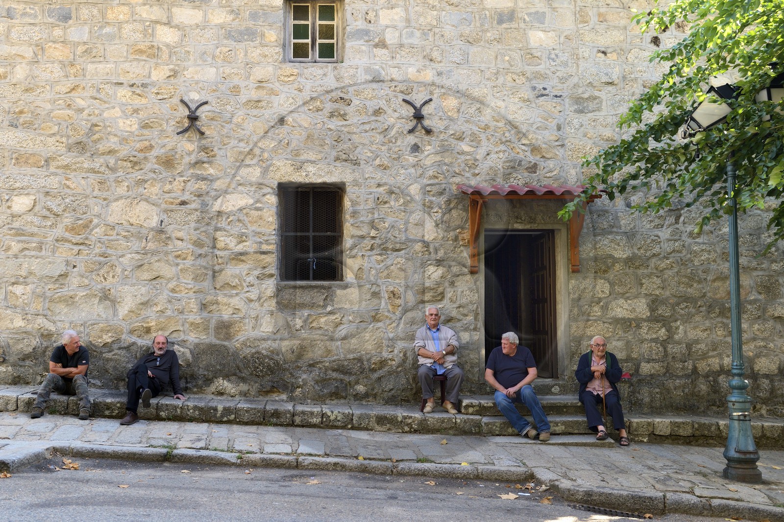 France, Corse-du-Sud (2A), Alta Rocca, Sainte-Lucie-de-Tallano (Santa Lucia di Tallà), hommes en discussion devant l'église du village France, Corse-du-Sud (2A), Alta Rocca, Sainte-Lucie-de-Tallano (Santa Lucia di Tallà), hommes en discussion devant l'église du village