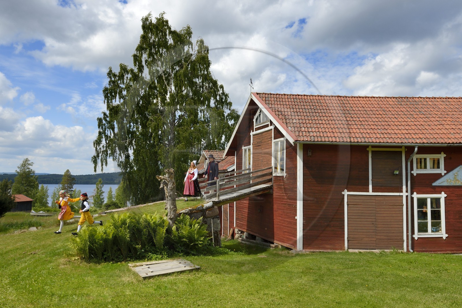 Suède, comté de Dalécarlie, région de Leksand, famille en costumes traditionnels pour les célébrations du solstice d'été dans le petit hameau de Sunnanäng sur la rive du lac Siljan