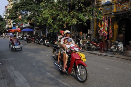 Vietnam, Hanoï, circulation d'une famille sans casque en moto dans la vieille ville