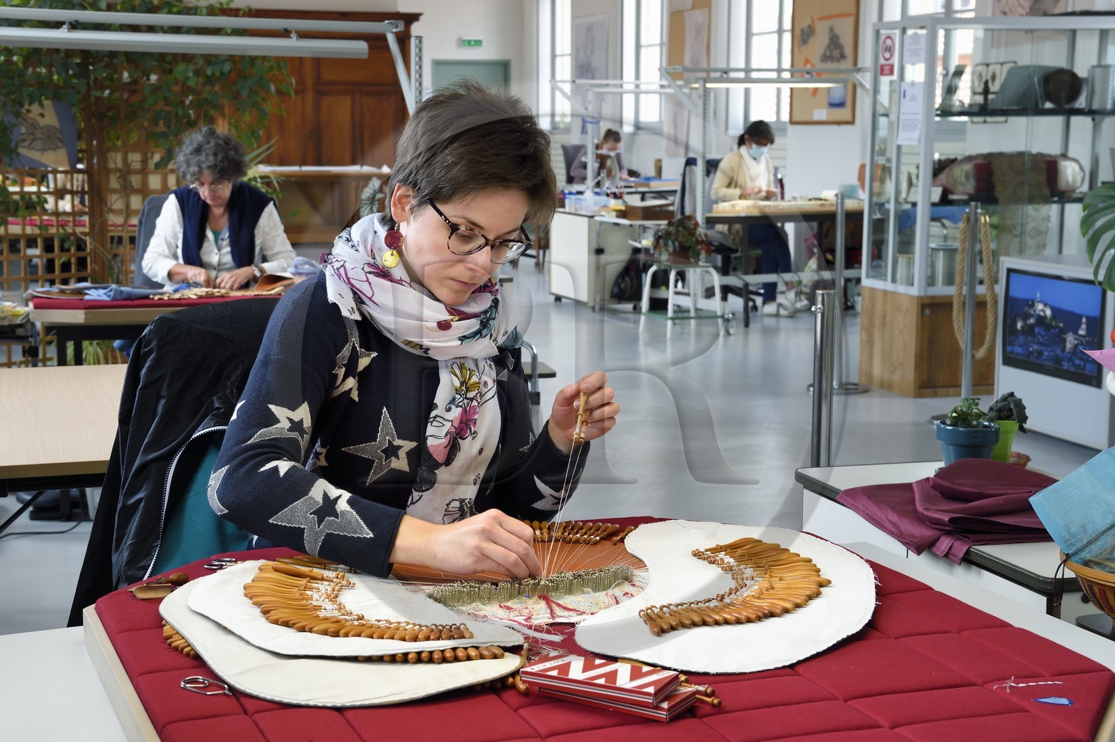 France, Haute-Loire (43), Le Puy-en-Velay, Atelier conservatoire national de la dentelle du Puy, dentelle au fuseau sur des créations d’artistes commandées par le département du mobilier national, la technicienne d'art (dentellière) Carole Cubizolles sur un carreau traditionnel