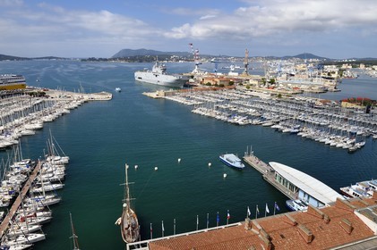 France, Var, Toulon, water bus pier of the Maritime Station quay Kronstadt on the civil port, the Mistral (L9013) amphibious helicopter carrier of the French Navy in the background in the naval base (Arsenal)