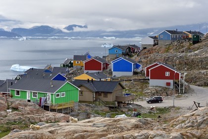 Groenland, cote ouest, baie de Baffin, la ville de Uummannaq accrochée à la roche et icebergs en arrière plan