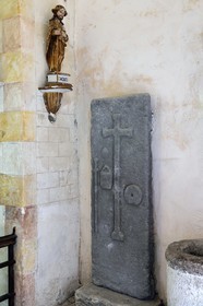 France, Cantal (15), étape sur le chemin de Saint-Jacques de Compostelle par la Via Arverna, Neussargues-Moissac, église Saint-Hilaire du XIIe siècle, tombe d'un pélerin du XVIIe siècle ayant effectué le chemin de St Jacques de Compostelle, dalle funéraire avec le bourdon, le sac et la coquille autour de la croix funéraire