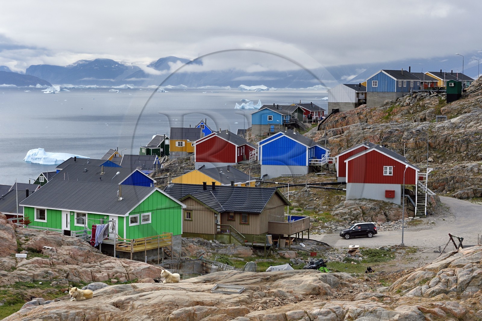 Greenland, west coast, Baffin bay, the town of Uummannaq clinging to the rock and icebergs in the background