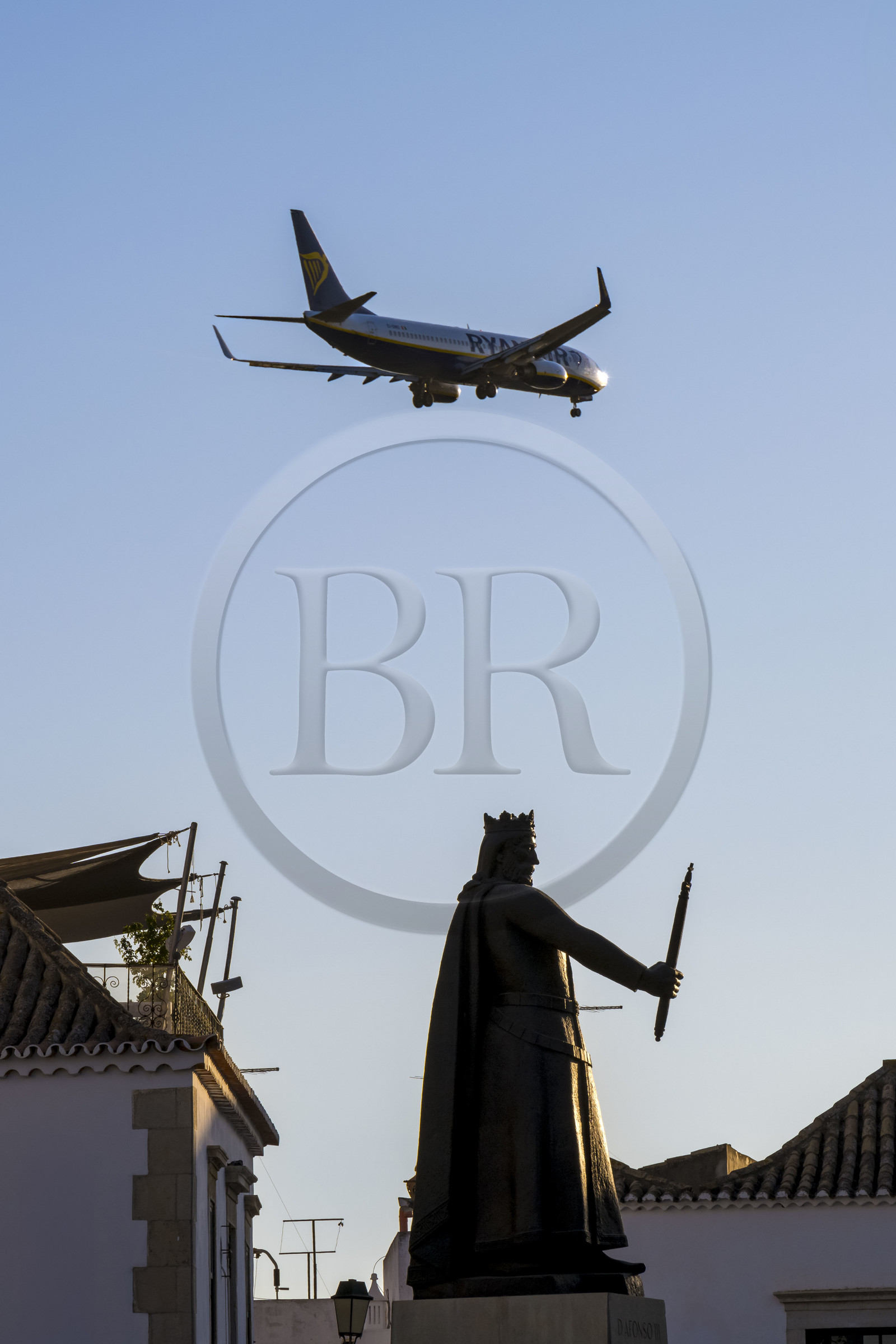 Portugal, Algarve, Faro, avion de ligne de la compagnie Ryanair à l'atterrissage au dessus de la vieille ville, statue Afonso III