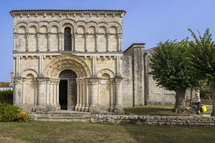 France, Charente Maritime, Echillais, cyclists traveling along the cycle route in front of the 12th century Romanesque church of Notre-Dame, classified as a historic monument
