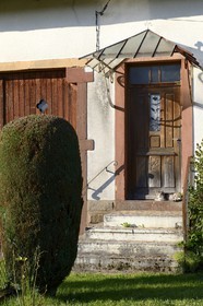 France, Moselle (57), Schaeferhof, chat devant la porte d'une maison traditionnelle des Vosges
