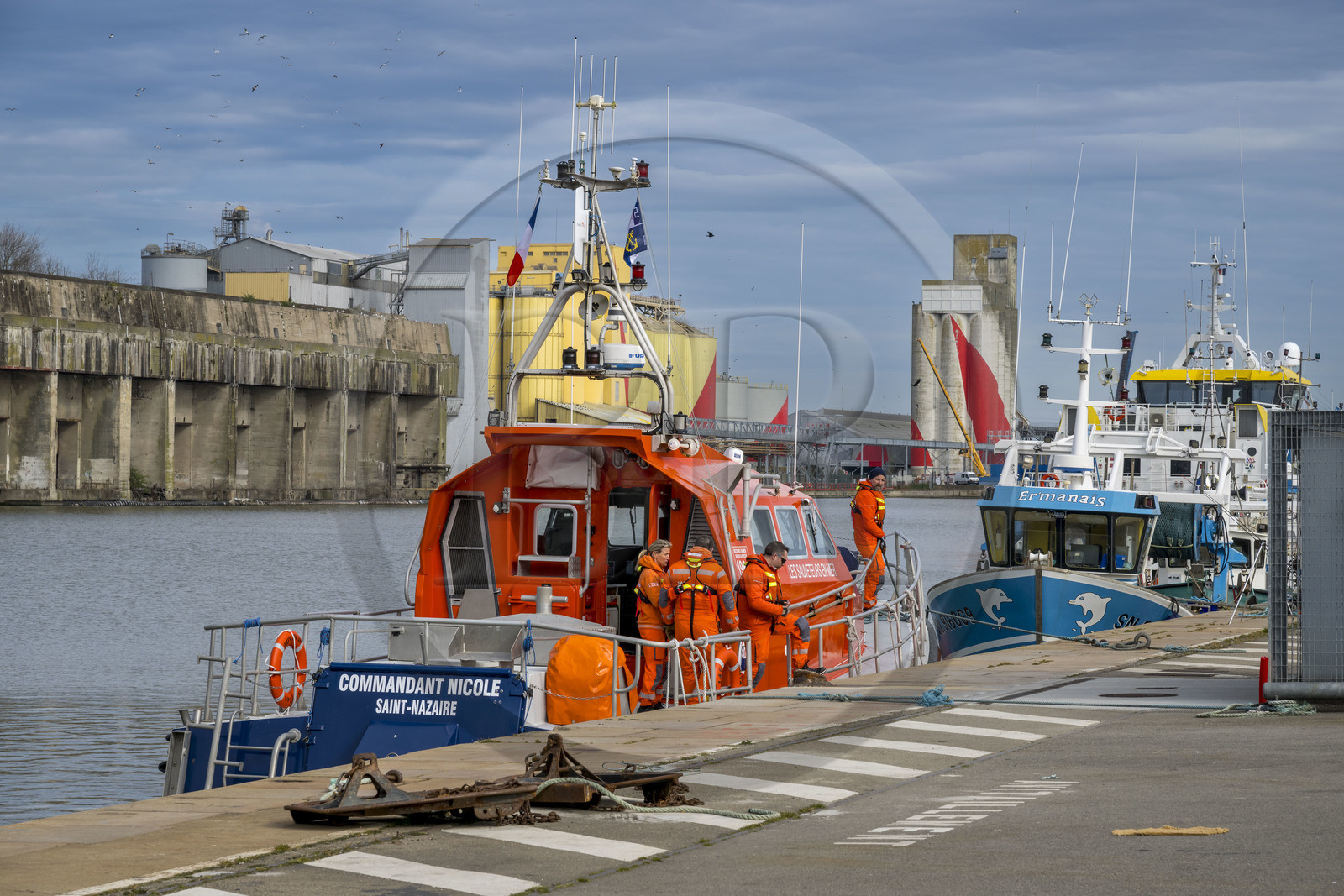 France, Loire-Atlantique (44), Saint-Nazaire, port de commerce, bateau de la SNSM (Société Nationale de Sauvetage en Mer) avec son équipage dans le bassin à flot et de l'ancienne base sous-marine allemande construite lors de la dernière guerre mondiale en arrière plan