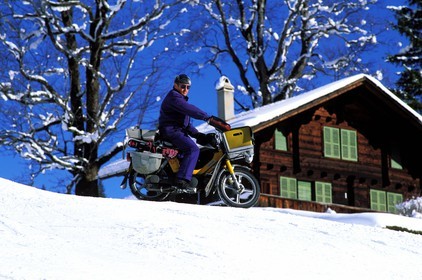 Switzerland, Bern Region (Bernese Oberland), Grindenwald, postman delivering on snow