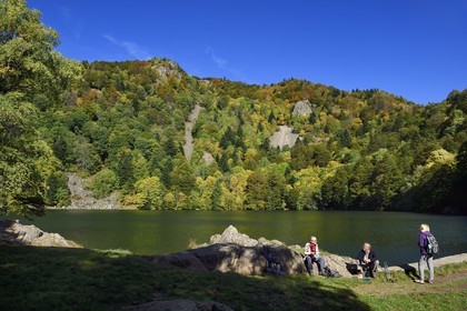 France, Haut Rhin, Ballons des Vosges Regional Natural Park, Rimbach pres Masevaux, hiker walking on the GR 531 hiking trail along the Lac des Perches under Gazon Rouge in the Vosges