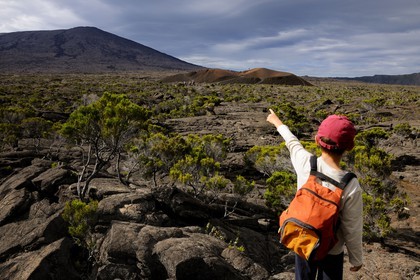 France, île de la Réunion, volcan du Piton de la Fournaise, classé Patrimoine Mondial de l'UNESCO, enfant pointant le cratère Formica Léo au premier plan et le cratère Dolomieu dans l'Enclos