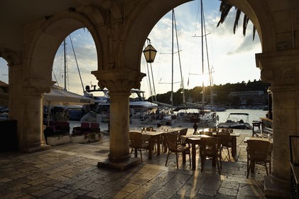 Croatia, Dalmatia, Dalmatian coast, Island of Hvar, restaurant tables on the town docks of Hvar