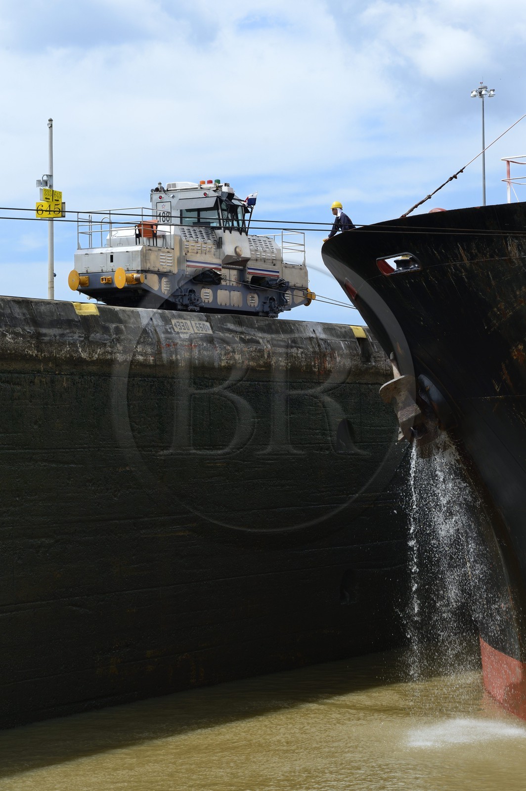 Panama, Canal de Panama, écluses de Pedro Miguel, mules mécaniques ou locomotives électriques guidant un cargo Panamax entre les murs de l'écluse