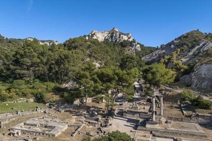 France, Bouches-du-Rhône (13), Parc Naturel Régional des Alpilles, Saint-Rémy-de-Provence, site archéologique de Glanum au pied du massif des Alpilles, colonnes et entablement reconstitués du petit temple géminé du premier forum au premier plan à droite (vue aérienne)