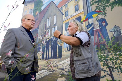France, Moselle, Fensch Valley, the painter Greg Gawra Gawra in front one of his works on the wall of the Nilvange post office