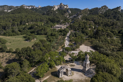 France, Bouches-du-Rhône (13), Parc Naturel Régional des Alpilles, Saint-Rémy-de-Provence, les Antiques de Glanum, cénotaphe gallo-romain érigé entre -30 et -20 av J.-C. élevé à la mémoire d'un homme de la famille des Julii et l'arc municipal de Glanum (arc de triomphe romain), le site archéologique de Glanum en arrière plan (vue aérienne)