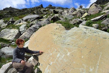 France, Alpes-Maritimes (06), parc national du Mercantour, Vallée des Merveilles parsemée de milliers de gravures rupestres de l'Age de bronze, l'archéologue Nicoletta Bianchi étudie la Roche de l’Eclat gravée de figures corniformes, de poignards et d'un grand réticulé qui symboliserait les champs cultivés