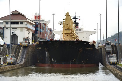 Panama, Canal de Panama, écluses de Miraflores, mules mécaniques ou locomotives électriques guidant un cargo Panamax entre les murs de l'écluse