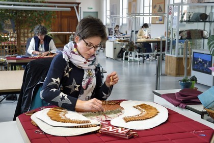France, Haute-Loire (43), Le Puy-en-Velay, Atelier conservatoire national de la dentelle du Puy, dentelle au fuseau sur des créations d’artistes commandées par le département du mobilier national, la technicienne d'art (dentellière) Carole Cubizolles sur un carreau traditionnel
