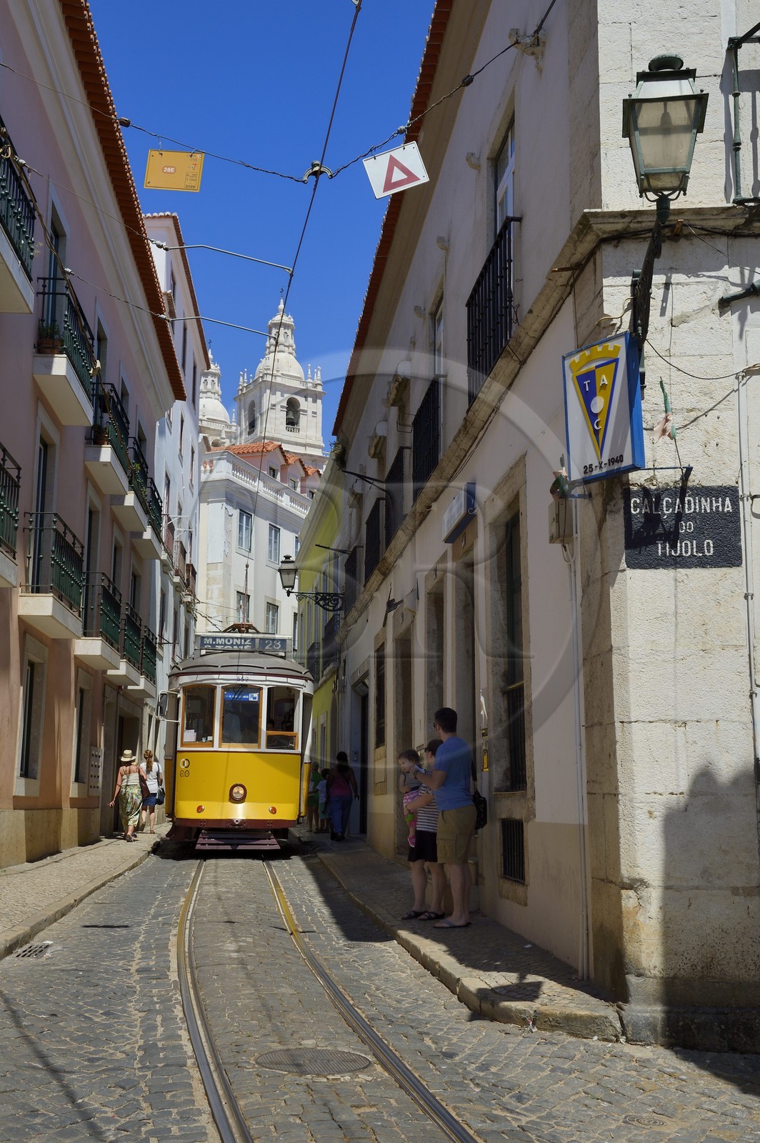 Portugal, Lisbon, Alfama district, tram (electricos) along Rua das Escolas Gerais with the tower of Sao Vicente de Fora church