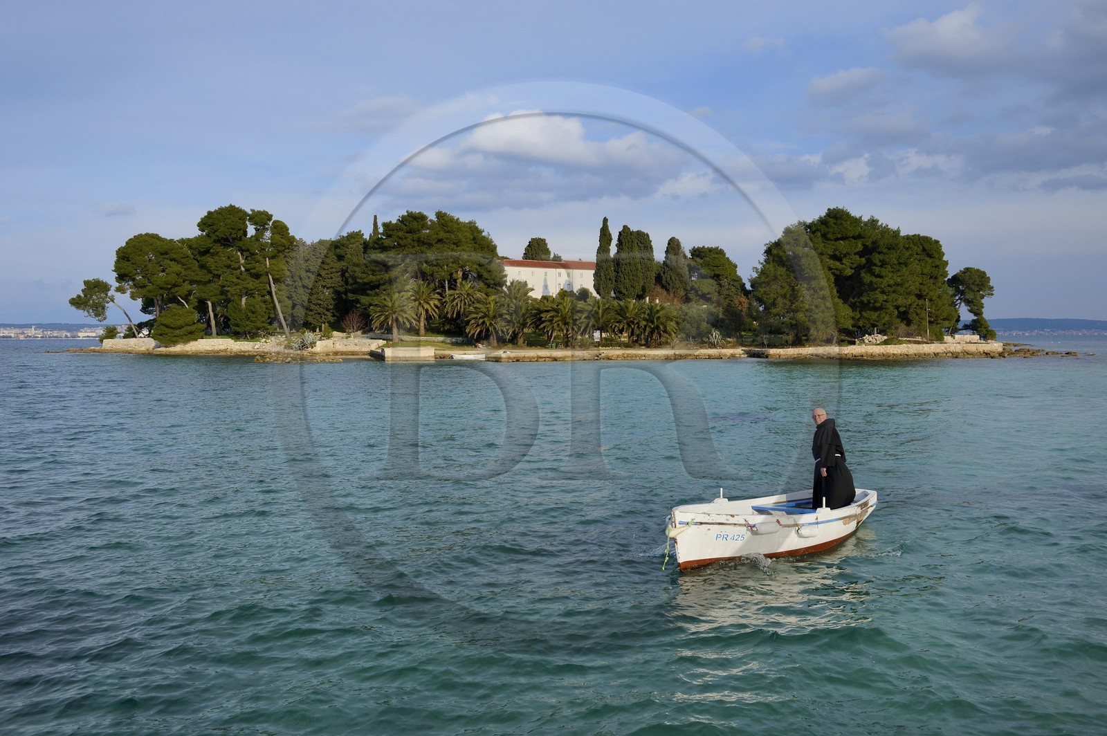 Croatie, Dalmatie, côte dalmate, Ile d’Ugljan, Preko, le frère franciscain Bozo Susic quittant le Monastère Franciscain de l'îlot Galovac sur sa barque