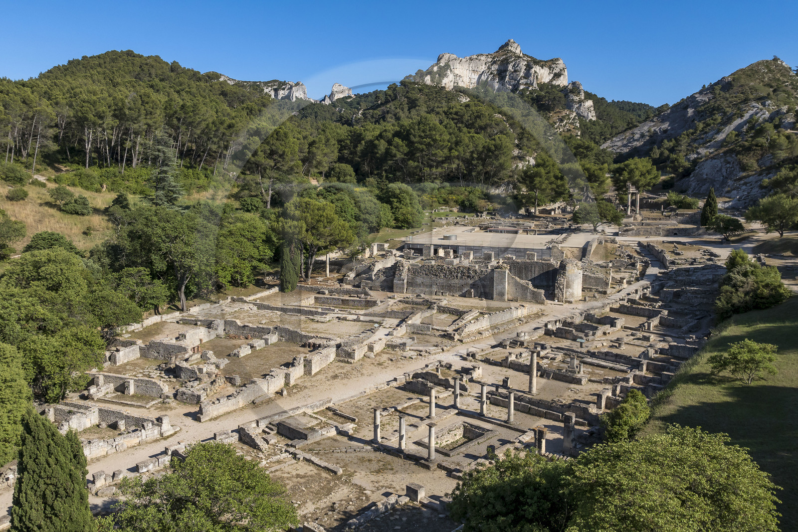 France, Bouches du Rhone, Regional Natural Park of the Alpilles, Saint Remy de Provence, site archéologique de Glanum at the foot of the Alpilles massif, house of Antes with peristyle and basin in the foreground on the right (aerial view)