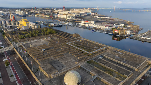 France, Loire Atlantique, Saint Nazaire, the former German submarine bases built during the last world war border the water basin of the port of Saint-Nazaire, in the background on the left the Penhoët basin and on the right the Saint-Nazaire bridge (aerial view)