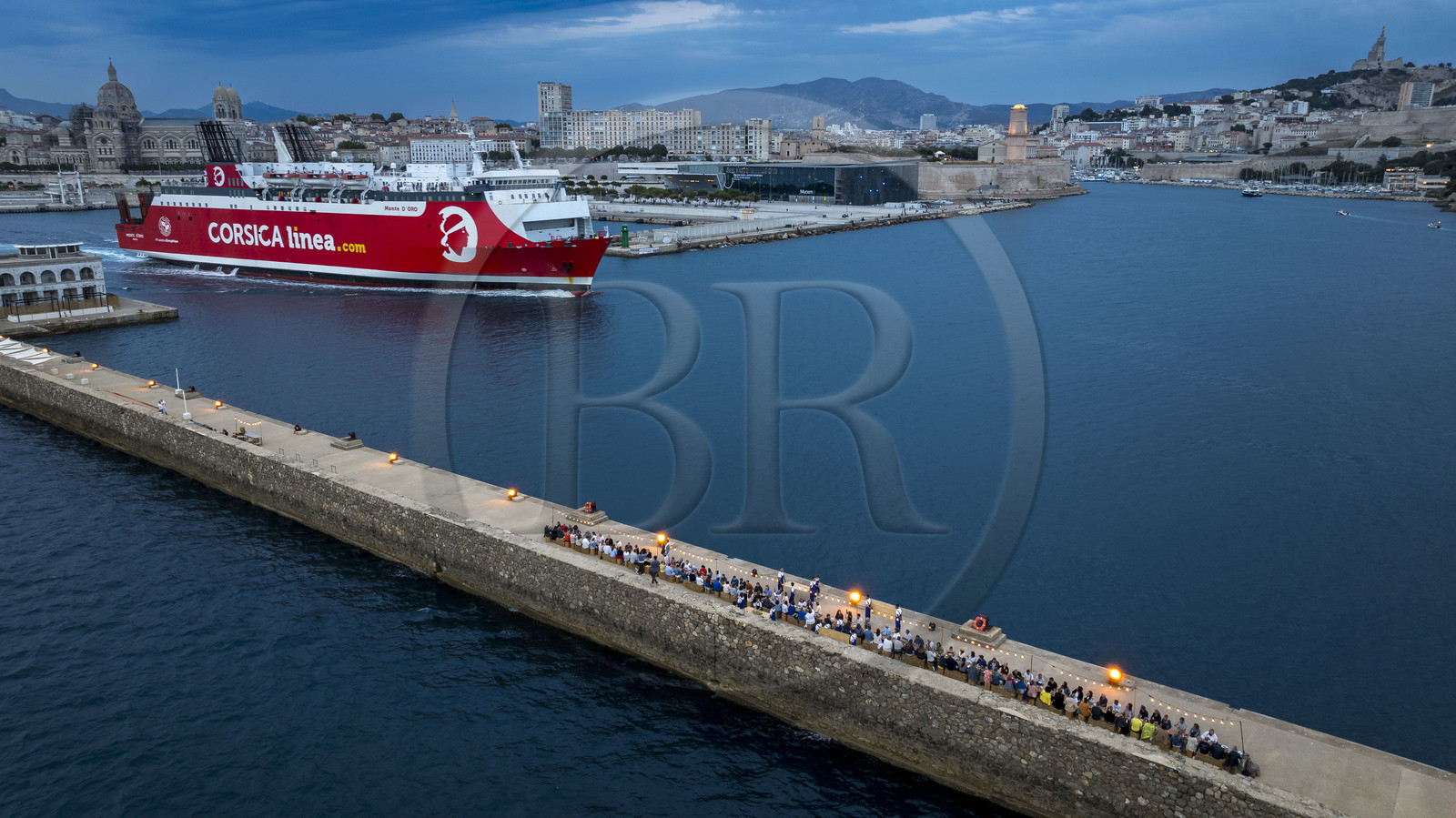 France, Bouches-du-Rhône (13), Marseille, Zone Euroméditerranée, grand port maritime de Marseille (GPMM), la digue du large, convives attablés à une grand table de banquet dressée par le chef Emmanuel Perrodin dans le cadre des Diners Insolites, un ferry de Corsica Linea quitte le port, le Mucem, le Fort Saint-Jean et la basilique Notre Dame de la Garde en arrière plan (vue aérienne)