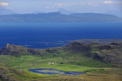 United Kingdom, Scotland, Highland, Inner Hebrides, Ardnamurchan peninsula facing the island of Mull, isolated farm at the small Loch Grigadale, Isle of Eigg in the background and Isle of Skye on the horizon (aerial view)