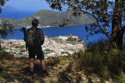 Italy, Sicily, Aeolian Islands, listed as World Heritage by UNESCO, Lipari Island, Lipari, hiker observing Lipari dominated by his citadel