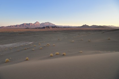 Iran, Province de Yazd, désert du Dasht-e Kavir, Moghestan, le massif montagneux de Moghestan face aux dunes dont la plus haute atteint les 200 mètres