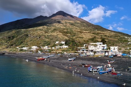 Italie, Sicile, iles Eoliennes, classées Patrimoine Mondial de l'UNESCO, ile de Stromboli, pecheurs sur la plage de Scari et le volcan actif du Stromboli en arrière plan (vue aérienne)