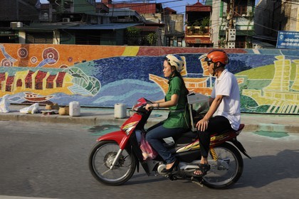 Vietnam, Hanoï, circulation en moto sur Tran Quang Khai le long de la digue, fresque réalisée pour le Millénaire de Hanoï