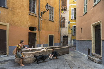 France, Alpes-Maritimes, Nice, listed as World Heritage by UNESCO, Old Nice, Virginie Acchiardo, chef of the restaurant Chez Acchiardo, walks her dog in front of the former washhouse in the rue de l'Ancien Sénat