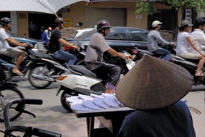 Vietnam, Hanoï, circulation en moto dans la vieille ville et vendeuse de tickets de loterie