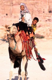 Jordan, Petra archaeological site, listed as World Heritage by UNESCO, a brother and his sister on a Dromedary