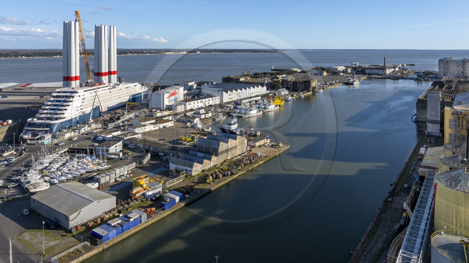 France, Loire-Atlantique (44), Saint-Nazaire, le chantier du super-yacht de luxe Ritz-Carlton Luminara dans la forme Joubert, les tours d'éoliennes à coté sont stockées avant embarquement (vue aérienne) France, Loire-Atlantique (44), Saint-Nazaire, le chantier du super-yacht de luxe Ritz-Carlton Luminara dans la forme Joubert, les tours d'éoliennes à coté sont stockées avant embarquement (vue aérienne)
