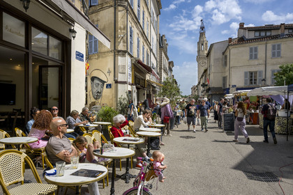 France, Vaucluse, Avignon, café terraces on the Place du Portail Matheron on a market day, the Augustins bell tower in the background