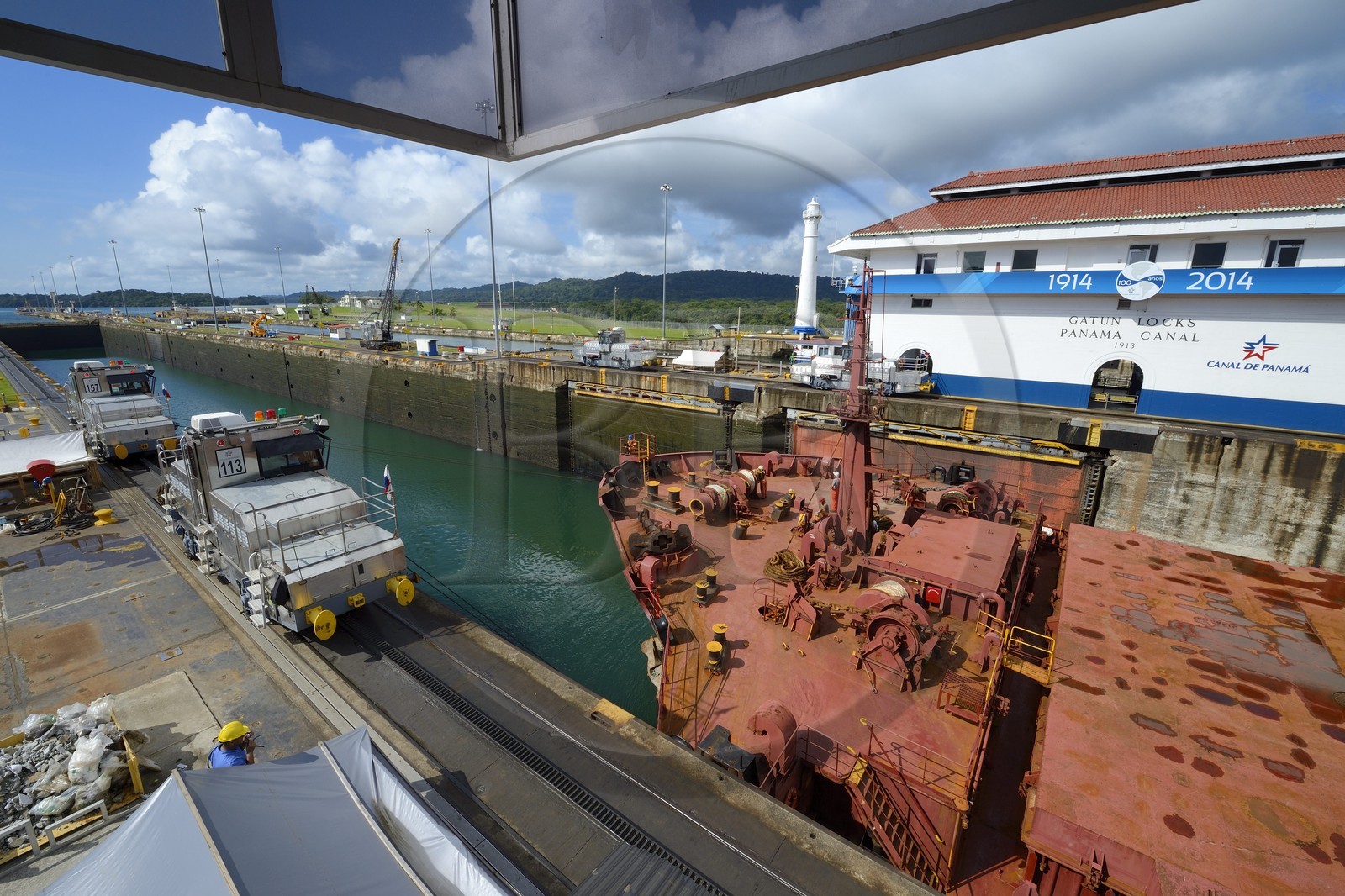 Panama, province de Colon, Canal de Panama, écluses de Gatun, mules mécaniques ou locomotives électriques guidant un cargo Panamax entre les murs de l'écluse