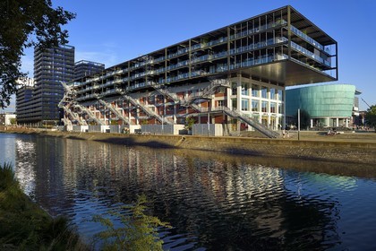 France, Bas Rhin, Strasbourg, development of port du Rhin (Rhine's harbour) and conversion of breakwater of Bassin d'Austerlitz, presqu'ile Malraux (Malraux peninsula), former Mole Seegmuller warehouse turned into commerce and residential flats on the edge of the Austerlitz basin, the buildings the Black Swans in the background
