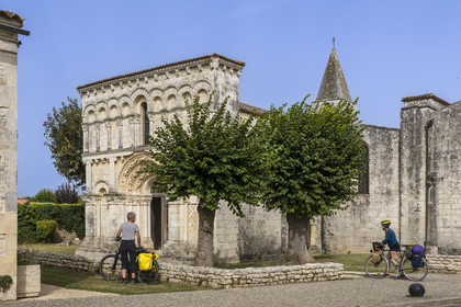 France, Charente Maritime, Echillais, cyclists traveling along the cycle route in front of the 12th century Romanesque church of Notre-Dame, classified as a historic monument