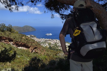 Italy, Sicily, Aeolian Islands, listed as World Heritage by UNESCO, Lipari Island, Lipari, hiker observing Lipari dominated by his citadel