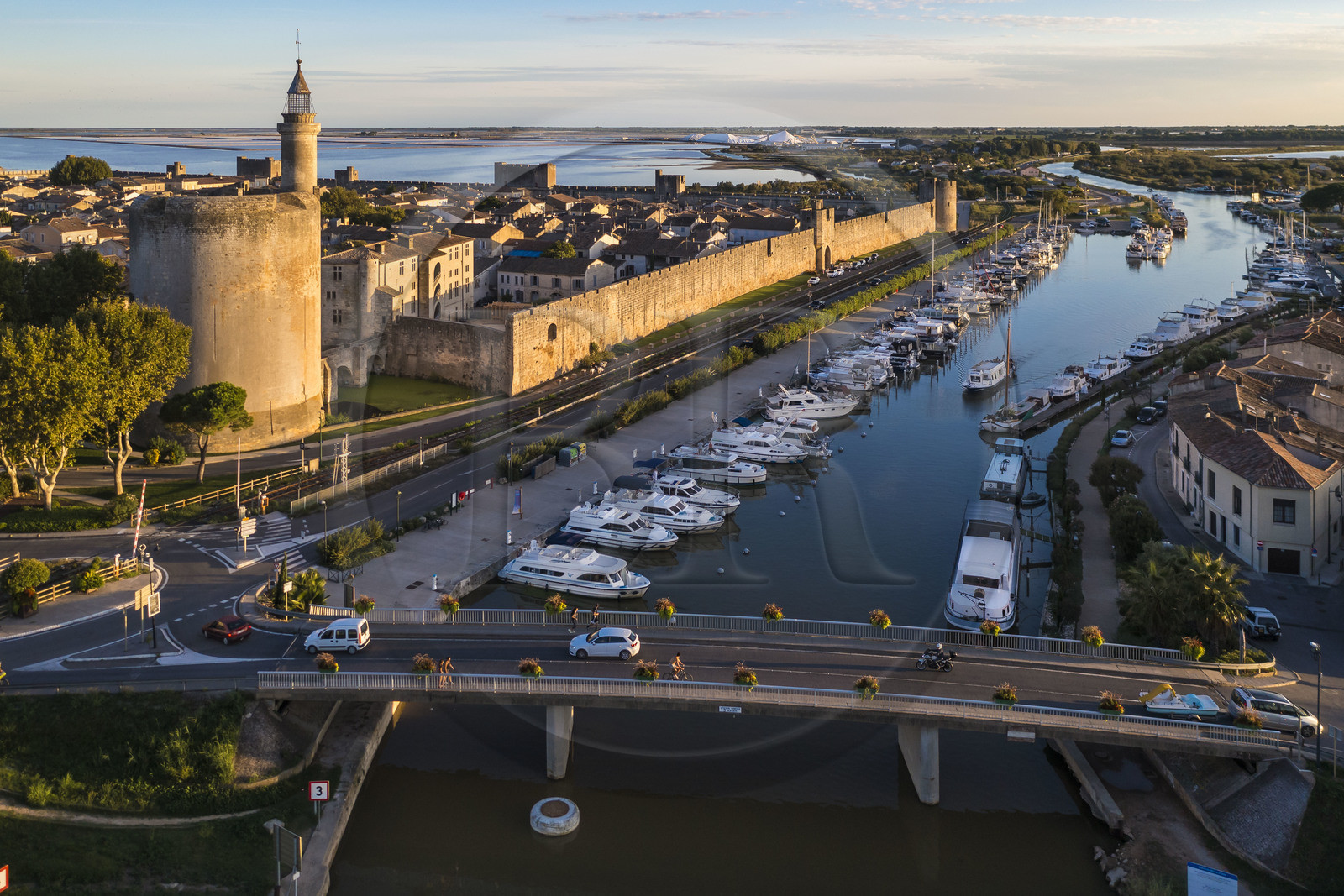 France, Gard (30), Aigues-Mortes, la ville médiévale entourée par ses remparts, la Tour de Constance et le port du canal du Rhône à Sète au premier plan, les marais salants (Salins du Midi) en arrière plan (vue aérienne)
