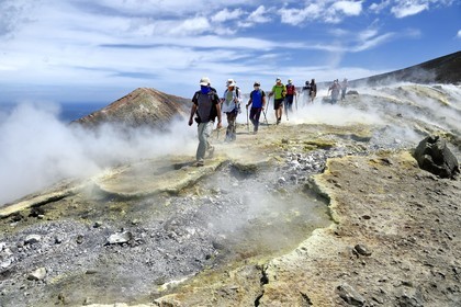 Italy, Sicily, Aeolian Islands, listed as World Heritage by UNESCO, Vulcano Island, hikers climbing the crater of volcano della Fossa through sulfur fumaroles