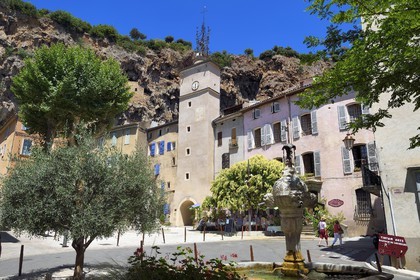 France, Var (83), Provence Verte, Cotignac, la Place de la Mairieet sa Tour de l'horloge en contrebas de la falaise de tuf de 80 mètres de haut et 400 mètres de large, fontaine de 1648 au premier plan