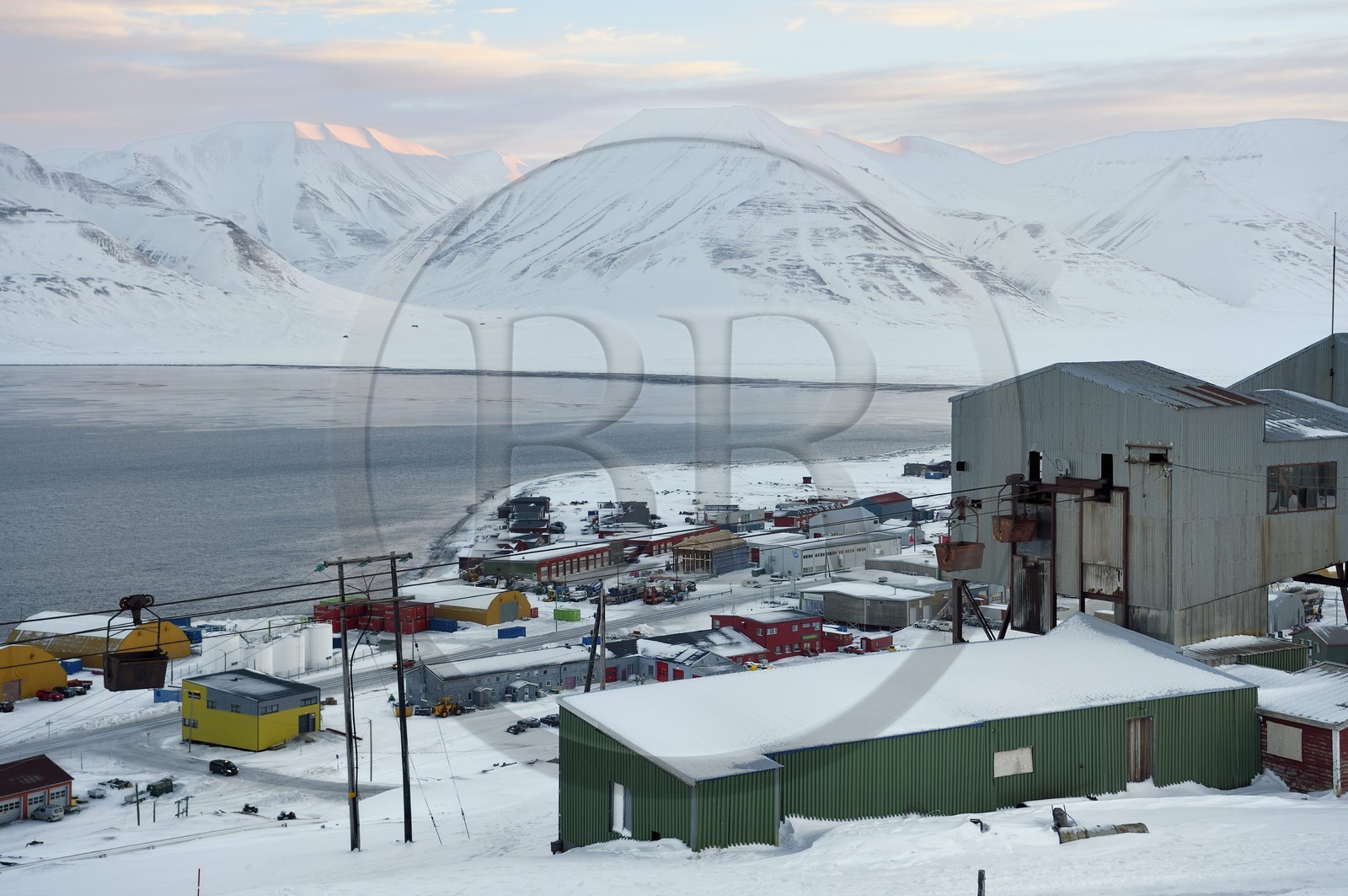 Norvège, Svalbard, Spitzberg, Longyearbyen, la zone industrielle de la ville et au premier plan le batiment central abandonné du téléphérique utilisé pour le transport des chariots de charbon des mines vers le port