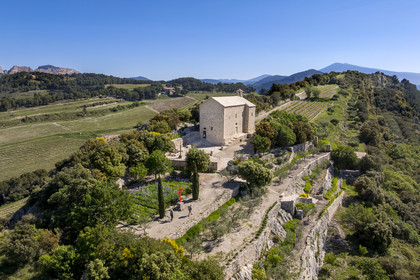 France, Vaucluse, Dentelles de Montmirail mountains, Beaumes de Venise, hikers reaching the Saint-Hilaire chapel, which dates back to the 6th century on the Courens plateau, with Mont Ventoux in the background (aerial view)